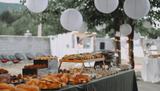 Stół w ogrodzie nakryty daniami z cateringu